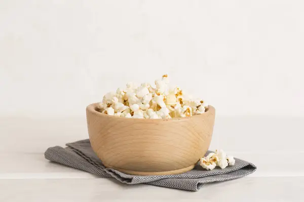Prepared popcorn in bowl on wooden table