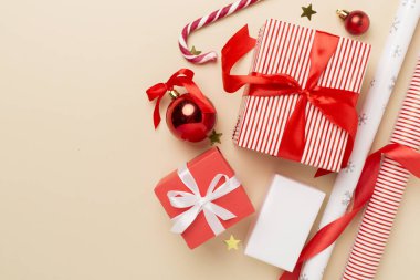 Kağıt kollu hediye kutuları ve renk arkaplanı üzerine noel süslemesi, üst görünüm