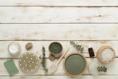 Ahşap arka planda kozmetik kil ve spa ürünleri ile kompozisyon, üst görünüm
