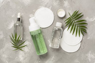 Beton arka planda eko pedleri olan yüz bakım ürünleri, üst görünüm