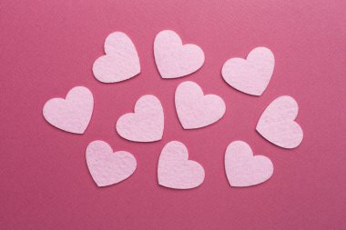 Felt hearts on color background, top view
