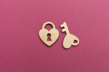 Wooden padlock with key on color background, top view