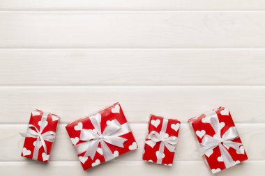 Gift boxes with hearts on wooden background, top view