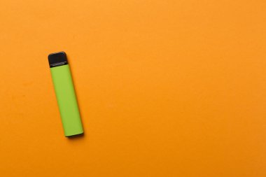 Disposable electronic cigarette on color background, top view