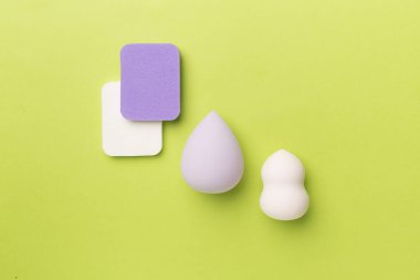 Beauty blenders on color background, top view