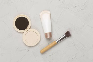 Beton arka planda cilt rengi için makyaj ürünleri bileşimi, üst görünüm