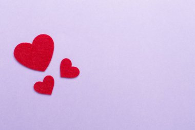 Felt hearts on color background, top view