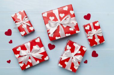 Gift boxes with hearts on wooden background, top view