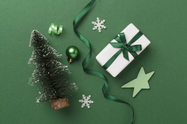 Arkaplanda hediye kutuları ve dekoru olan minyatür noel ağacı