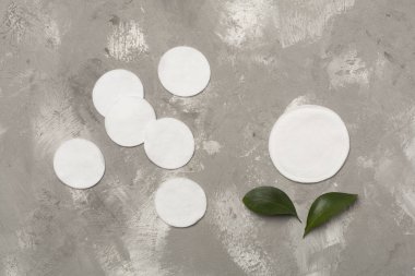 Beton arka planda tek kullanımlık pamuk pedleri, üst görünüm