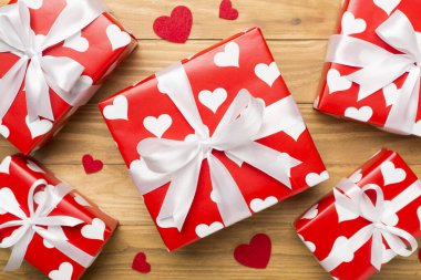 Gift boxes with hearts on wooden background, top view