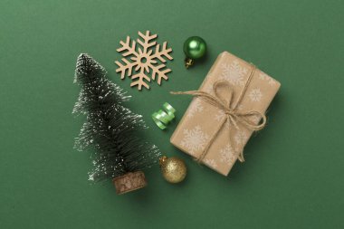 Arkaplanda hediye kutuları ve dekoru olan minyatür noel ağacı