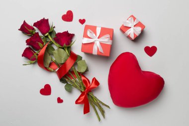 Valentines day gifts with red roses on color background, top view