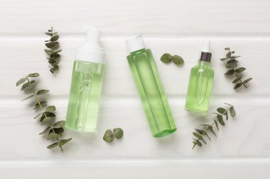 Ahşap arka planda bitkisel yüz bakım ürünleri, üst görünüm