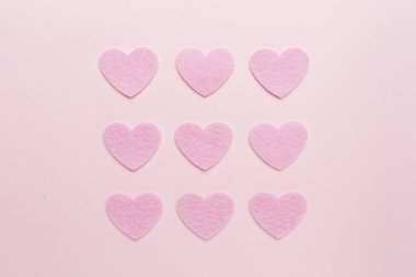 Felt hearts on color background, top view
