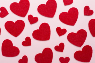 Felt hearts on color background, top view