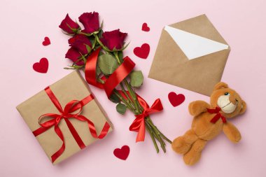 Valentines day gifts with red roses on color background, top view