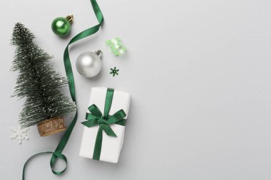 Arkaplanda hediye kutusu ve dekoru olan minyatür noel ağacı