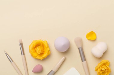 Renk arkaplanında makyaj fırçaları ve süngerler, üst görünüm