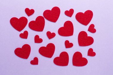 Felt hearts on color background, top view