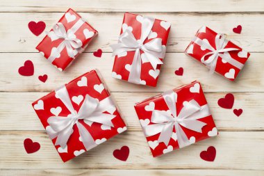 Gift boxes with hearts on wooden background, top view