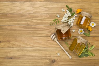 Ahşap zemin üzerinde farklı bal türleri olan kavanozlar, üst görünüm