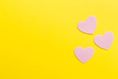 Felt hearts on color background, top view