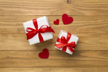 Gift boxes with hearts on wooden background, top view