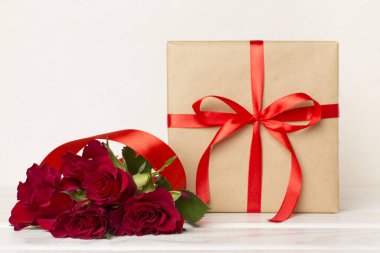 Valentines day gift box with red roses on white table