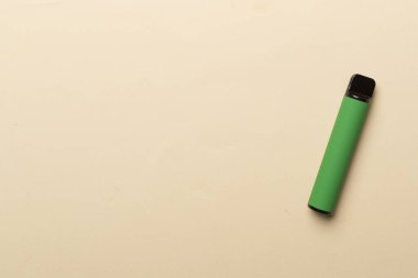 Disposable electronic cigarette on color background, top view