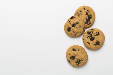 Beyaz arka planda çikolatalı kurabiyelerle yatıyordu.