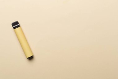 Disposable electronic cigarette on color background, top view