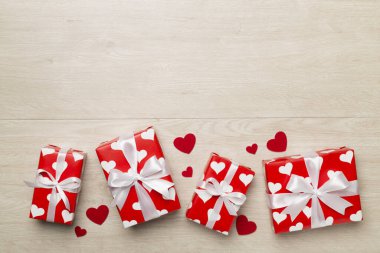 Gift boxes with hearts on wooden background, top view