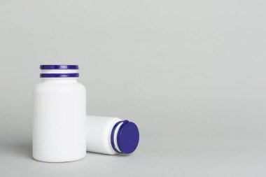 Renk arkaplanındaki vitaminler için plastik şişeler