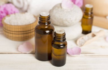 Ahşap masanın üzerinde pembe güller olan spa kompozisyonu