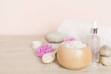 Ahşap masanın üzerinde pembe güller olan spa kompozisyonu