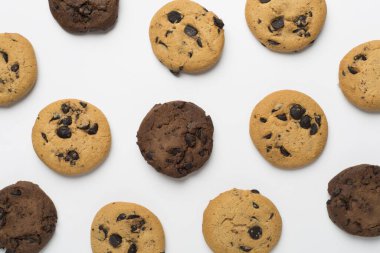 Beyaz arka planda çikolatalı kurabiyelerle yatıyordu.