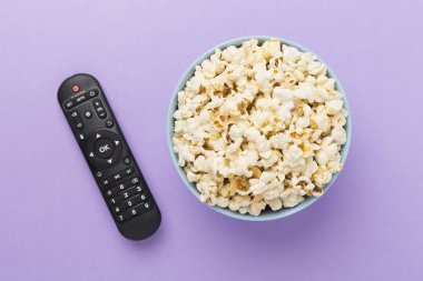 Patlamış mısır ve televizyon uzaktan kumandası renk arkaplanında