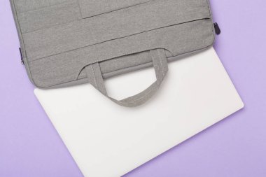 Renkli arka planda aygıtı olan gri renkli dizüstü bilgisayar çantası, üst görünüm