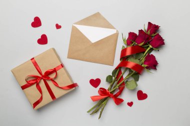 Valentines day gifts with red roses on color background, top view