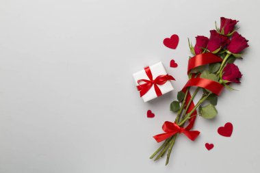 Valentines day gifts with red roses on color background, top view