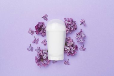 Renk arkaplan üzerinde deodorant ve çiçeklerle kompozisyon, üst görünüm