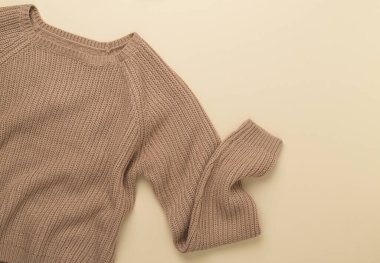 Renkli arka planda bej örülmüş süveter, üst görünüm