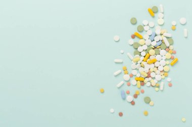 Farklı ilaç ve kapsüller. Renkli arka plan, üst görünüm.
