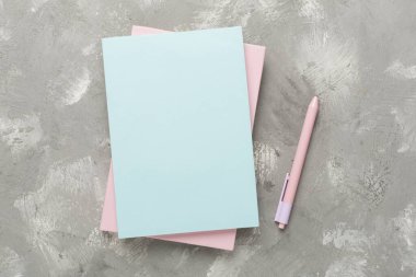 Beton zemin üzerinde kırtasiye malzemesi olan defterler, üst görünüm