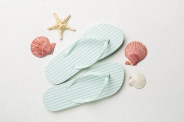 Beton arka planda çizgili parmak arası terlikler, üst görünüm