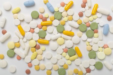 Farklı ilaç ve kapsüller. Renkli arka plan, üst görünüm.