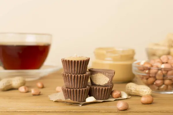 Tasty chocolate peanut butter cups on wooden table