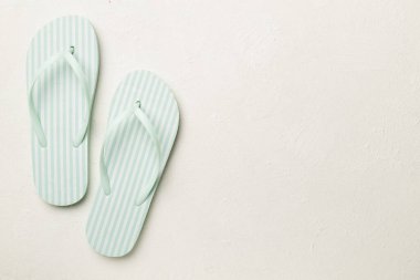 Beton arka planda çizgili parmak arası terlikler, üst görünüm