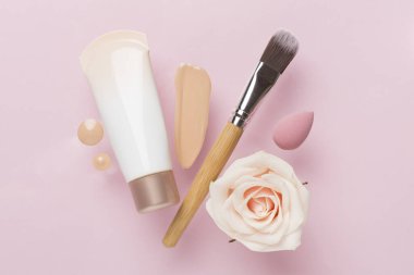 Renk arkaplanında makyaj temeli olan kompozisyon, üst görünüm